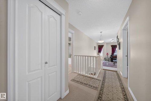Interior hallway featuring neutral wall paint, carpet flooring, white trim, and a white baluster railing - 2518 33A Avenue Nw, Edmonton, AB - Indoor Photo Showing Other Room