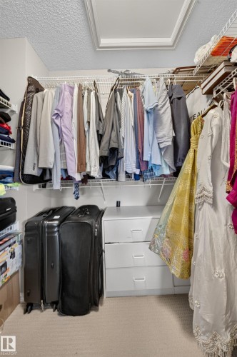 Built-in wardrobe system with multiple hanging rods and shelving - 2518 33A Avenue Nw, Edmonton, AB - Indoor With Storage