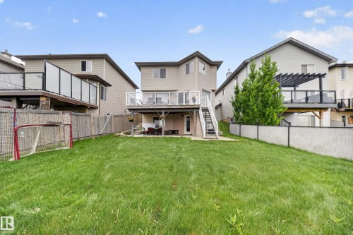 Expansive grassy yard with a two-story residence and a raised deck with white railings - 2518 33A Avenue Nw, Edmonton, AB - Outdoor With Deck Patio Veranda