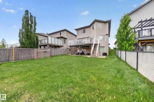 Expansive grassy backyard featuring a wooden privacy fence and chain link fencing - 2518 33A Avenue Nw, Edmonton, AB - Outdoor With Backyard