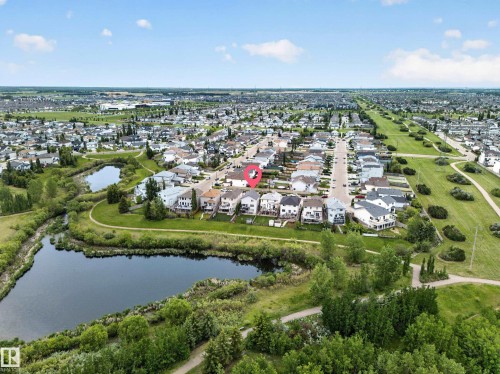 Residential neighborhood featuring a natural pond, extensive green spaces, and paved walking paths - 2518 33A Avenue Nw, Edmonton, AB - Outdoor With View