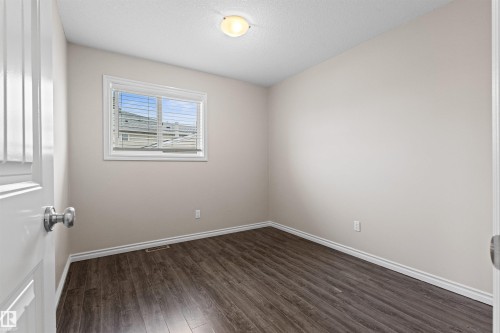 Neutral wall tones complement the wood-finish flooring in this room - 10634 155 Street Nw, Edmonton, AB - Indoor Photo Showing Other Room