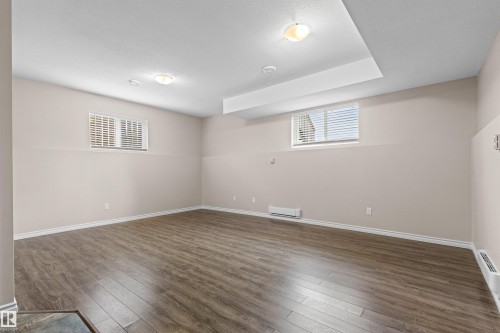 Spacious room featuring wood-finish flooring, neutral paint tones, and window blinds - 10634 155 Street Nw, Edmonton, AB - Indoor Photo Showing Other Room