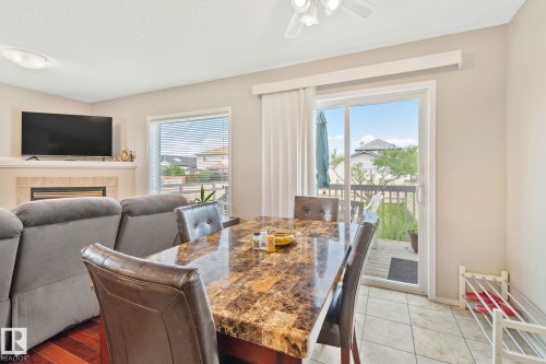 Dining area with tile flooring and sliding glass door access to an outdoor deck - 3769 21 Street Nw, Edmonton, AB - Indoor Photo Showing Dining Room With Fireplace