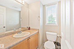 Bathroom vanity with a laminate countertop, integrated sink, and light wood-finish cabinetry - 
