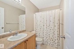 Bathroom featuring a wood-finish vanity with an integrated sink and laminate countertop - 