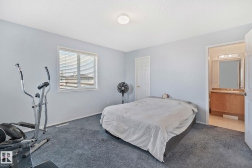 Carpeted room with light blue walls and a window featuring horizontal blinds - 3769 21 Street Nw, Edmonton, AB - Indoor Photo Showing Bedroom