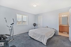 Carpeted room with light blue walls and a window featuring horizontal blinds - 