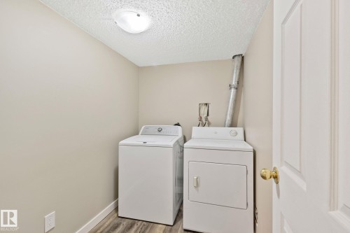 Dedicated laundry area with a top-load washer and front-load dryer - 3769 21 Street Nw, Edmonton, AB - Indoor Photo Showing Laundry Room