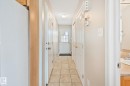 Hallway with neutral tile flooring leading to an exterior door with frosted glass insert - 3769 21 Street Nw, Edmonton, AB  - Indoor Photo Showing Other Room 