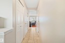 Hallway featuring neutral wall tones, tiled flooring, white panel doors, and gold-tone hardware - 3769 21 Street Nw, Edmonton, AB  - Indoor Photo Showing Other Room 