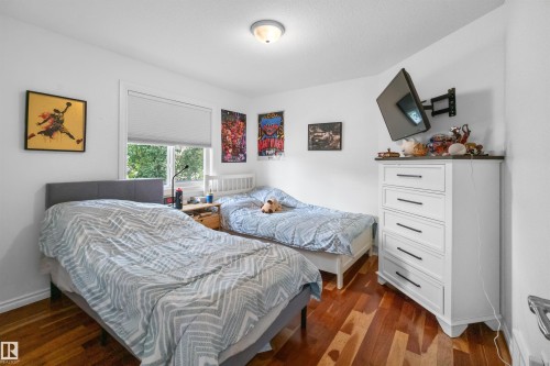 Hardwood flooring, white walls, and a window with blinds - 6515 37 Avenue, Beaumont, AB - Indoor Photo Showing Bedroom