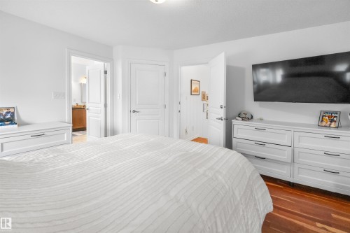 Hardwood flooring, painted interior doors, and crisp white wall finishes - 6515 37 Avenue, Beaumont, AB - Indoor Photo Showing Bedroom
