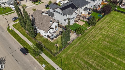 Corner property featuring a large backyard, paved street, and mature trees - 6515 37 Avenue, Beaumont, AB - Outdoor With View