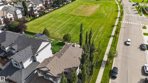 Asphalt shingle roofing, mature trees, concrete sidewalks, and an expansive green space - 6515 37 Avenue, Beaumont, AB - Outdoor