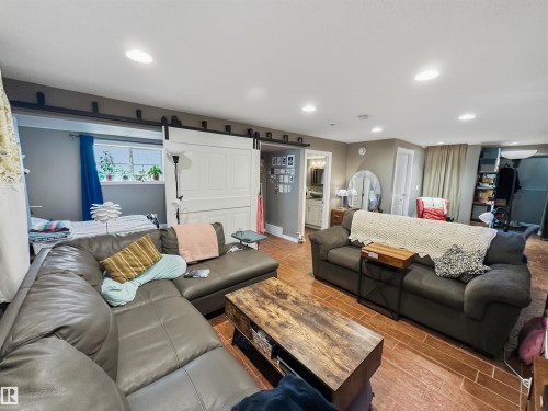 Recessed ceiling lighting, wood-finish flooring, and white barn-style sliding doors - 6515 37 Avenue, Beaumont, AB - Indoor