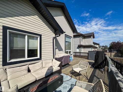 Expansive wood-finish deck with black railing and light-colored siding exterior with black trim - 6515 37 Avenue, Beaumont, AB - Outdoor With Exterior
