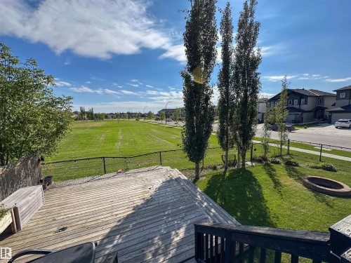 Spacious wood-finish deck overlooking a landscaped lawn with a built-in fire pit - 6515 37 Avenue, Beaumont, AB - Outdoor With View