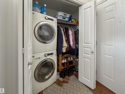 Stacked washer and dryer unit, built-in shelving, and a hanging clothes rod within a closet space - 6515 37 Avenue, Beaumont, AB - Indoor Photo Showing Laundry Room