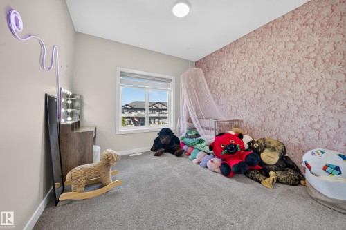 Wall-to-wall carpeting, window with roller blinds, and a patterned accent wall - 4301 38 St, Beaumont, AB - Indoor