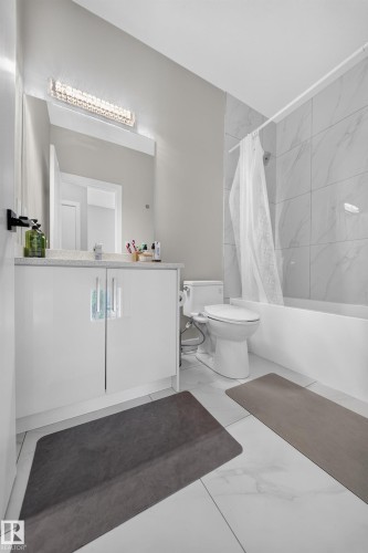 White vanity with polished chrome hardware and a quartz-finish countertop - 4301 38 St, Beaumont, AB - Indoor Photo Showing Bathroom