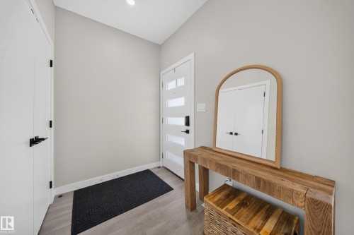 Recessed ceiling lighting, modern entry door with frosted glass panels, wood-finish flooring, and white trim - 4301 38 St, Beaumont, AB - Indoor Photo Showing Other Room
