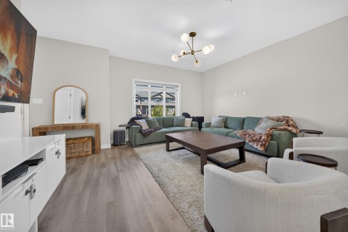 Recessed lighting, wood-finish flooring, large window, and a contemporary light fixture - 4301 38 St, Beaumont, AB - Indoor Photo Showing Living Room