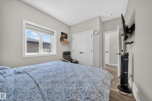 White framed window with privacy blind, light gray wall paint, and wood-finish flooring - 4301 38 St, Beaumont, AB - Indoor Photo Showing Bedroom