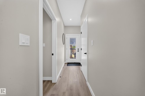 Recessed lighting, light wood-finish flooring, white trim, and a full-light door - 4301 38 St, Beaumont, AB - Indoor Photo Showing Other Room