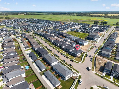 Aerial perspective of a developed residential community featuring consistent architectural styles and dark-toned roofing - 4301 38 St, Beaumont, AB - Outdoor With View