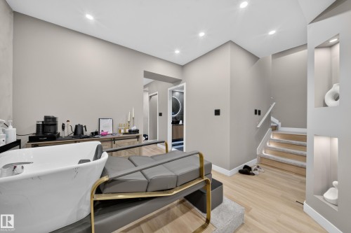 Recessed lighting illuminates the space, featuring light wood-finish flooring and a staircase with carpeted treads - 4301 38 St, Beaumont, AB - Indoor