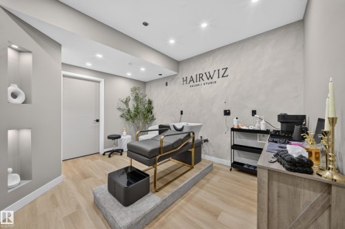 Recessed wall niches with accent lighting, light wood-finish flooring, recessed ceiling lighting, textured accent wall, and solid core door - 4301 38 St, Beaumont, AB - Indoor Photo Showing Other Room