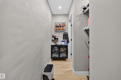 Recessed ceiling lighting illuminates the hallway with wood-finish flooring - 4301 38 St, Beaumont, AB - Indoor