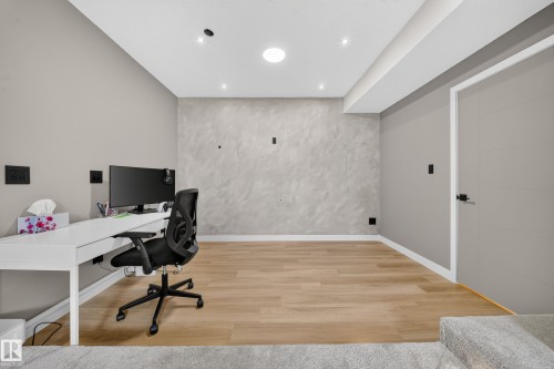 Recessed ceiling lighting, wood-finish flooring, a textured accent wall, and a built-in ceiling light - 4301 38 St, Beaumont, AB - Indoor Photo Showing Office