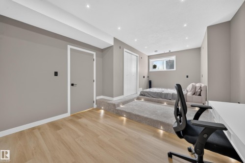 Wood-finish flooring, recessed ceiling lighting, built-in carpeted platform with accent lights, and a window with white trim - 4301 38 St, Beaumont, AB - Indoor Photo Showing Office