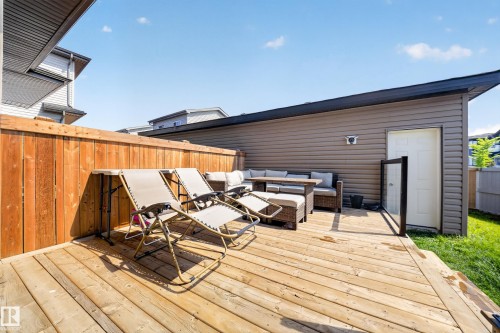 Expansive wooden deck with a privacy fence, wood-paneled exterior structure, and a service door - 4301 38 St, Beaumont, AB - Outdoor With Deck Patio Veranda With Exterior