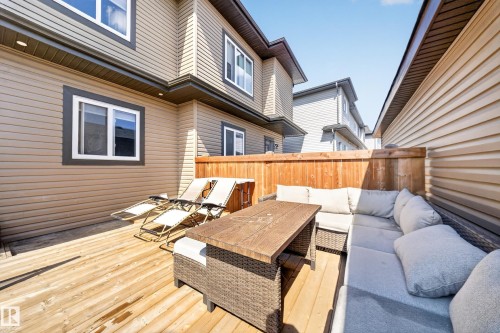 Spacious wooden deck featuring a privacy fence, exterior siding, and multiple windows - 4301 38 St, Beaumont, AB - Outdoor With Deck Patio Veranda With Exterior