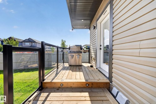 Wood-finish deck with integrated step lighting and black frame glass railings - 4301 38 St, Beaumont, AB - Outdoor With Deck Patio Veranda With Exterior