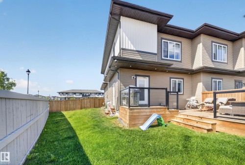 Expansive backyard with a manicured lawn, multi-level wood deck, and partial privacy fencing - 4301 38 St, Beaumont, AB - Outdoor With Deck Patio Veranda