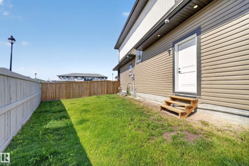 Exterior siding with an entry door and wood steps - 4301 38 St, Beaumont, AB - Outdoor With Exterior