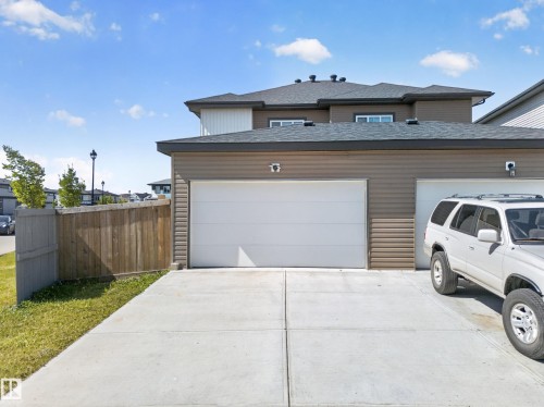Exterior featuring a two-car garage, concrete driveway, wood privacy fence, and horizontal siding - 4301 38 St, Beaumont, AB - Outdoor With Exterior