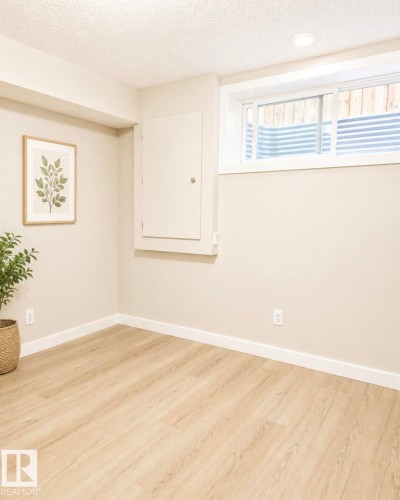 Wood-finish flooring, recessed lighting, and a sliding window with a window well - 5135 1A Avenue Sw, Edmonton, AB - Indoor Photo Showing Other Room