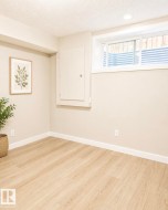 Wood-finish flooring, recessed lighting, and a sliding window with a window well - 