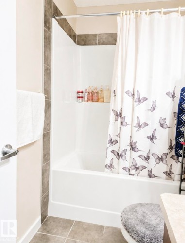 Bathtub-shower combination with tiled surround, and integrated shelf - 5135 1A Avenue Sw, Edmonton, AB - Indoor Photo Showing Bathroom
