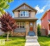 Craftsman-style exterior with shingle and siding accents, stone veneer columns, front porch with railing, and concrete walkway - 5135 1A Avenue Sw, Edmonton, AB 