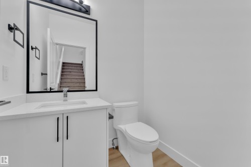 White vanity with integrated sink, chrome faucet, and black hardware - 82 Patriot Way, Spruce Grove, AB - Indoor Photo Showing Bathroom