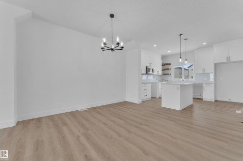 Open-concept living area with wood-finish flooring, a modern chandelier, and recessed lighting - 82 Patriot Way, Spruce Grove, AB - Indoor Photo Showing Kitchen With Upgraded Kitchen