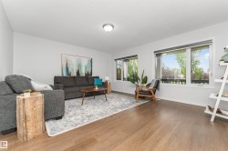 Vinyl flooring throughout, white painted walls, and white trim with large triple pane windows with a view of the park. - 