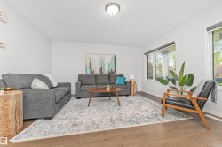 Vinyl flooring, white painted walls, and multiple windows showcasing the beautifully manicured park. - 
