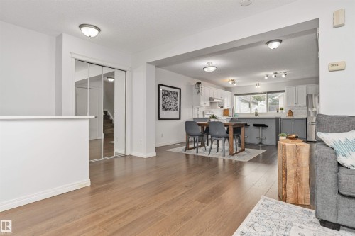 Vinyl flooring throughout, mirrored closet doors, and large dining room and kitchen. - 4121 Tompkins Way Nw, Edmonton, AB - Indoor Photo Showing Living Room